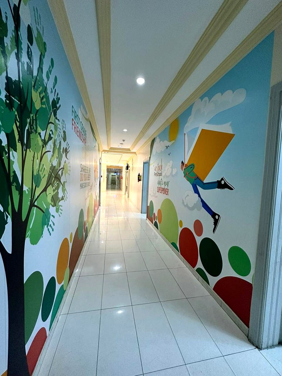 Bright ARWA corridor with hand-painted learning murals