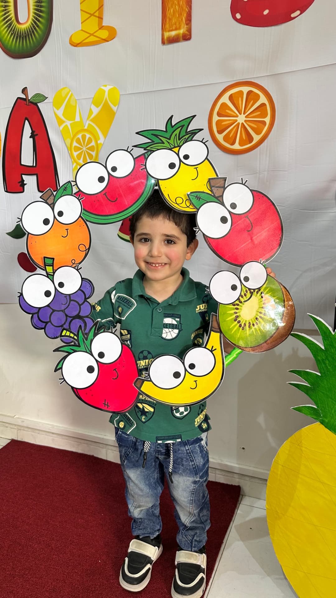 Early Years pupil at ARWA Fruits Day holding a decorated wreath